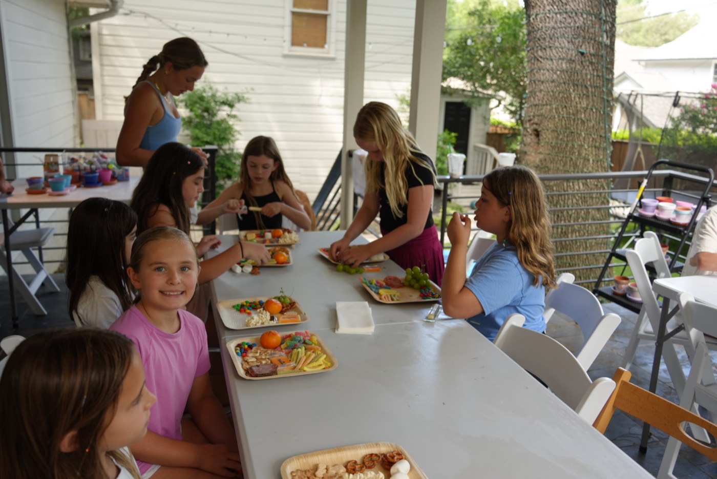 Campers seated along a long table assembling snack trays.